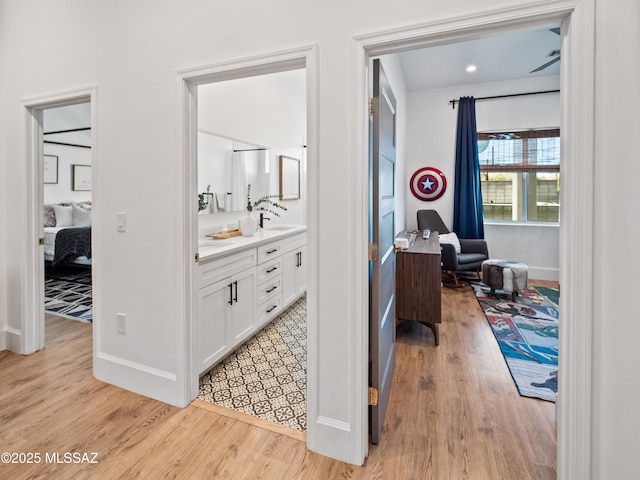 2540 W Oasis Springs Ct, Tucson, AZ 85742 - hallway featuring baseboards, a sink, and light wood-style flooring