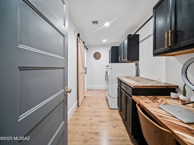 2540 W Oasis Springs Ct, Tucson, AZ 85742 - laundry room featuring visible vents, a barn door, cabinet space, light wood-style flooring, and washer and clothes dryer