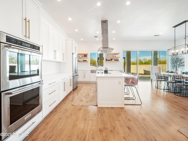 2540 W Oasis Springs Ct, Tucson, AZ 85742 - kitchen with stainless steel appliances, open shelves, white cabinetry, and island exhaust hood