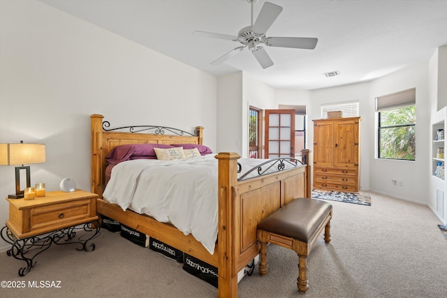 bedroom featuring visible vents, a ceiling fan, baseboards, and light carpet