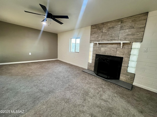 unfurnished living room featuring a ceiling fan, baseboards, carpet, and a fireplace