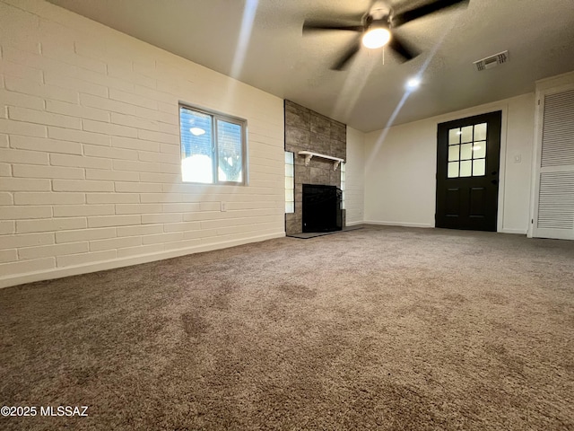 unfurnished living room featuring visible vents, baseboards, carpet floors, a fireplace, and a ceiling fan