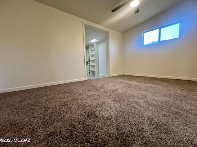 empty room with vaulted ceiling, baseboards, a ceiling fan, and carpet floors