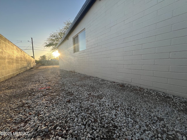 view of side of home featuring fence