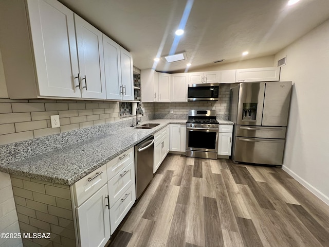 kitchen featuring wood finished floors, visible vents, stainless steel appliances, and a sink