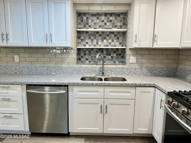 kitchen with white cabinetry, appliances with stainless steel finishes, decorative backsplash, and a sink