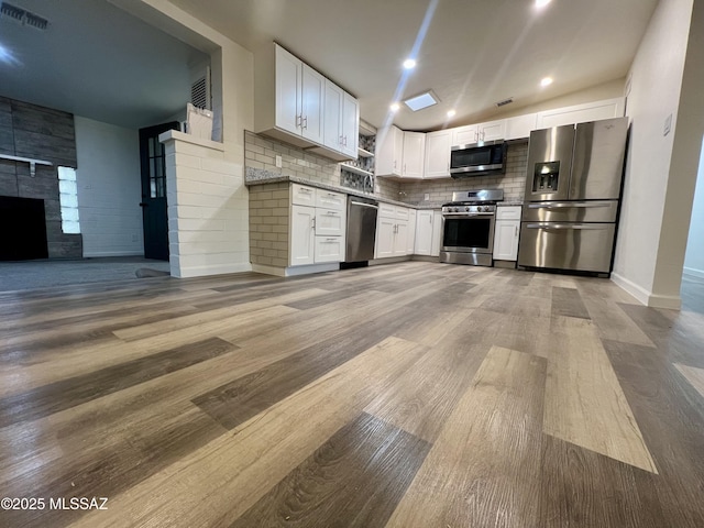 kitchen featuring stainless steel appliances, light wood-style floors, white cabinetry, visible vents, and open floor plan