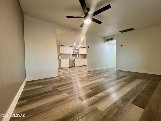 unfurnished living room with visible vents, ceiling fan, wood finished floors, and baseboards