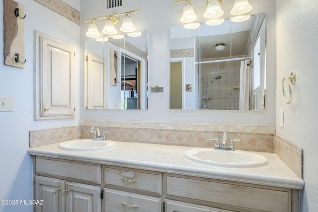 full bathroom with double vanity, a sink, a shower stall, and backsplash