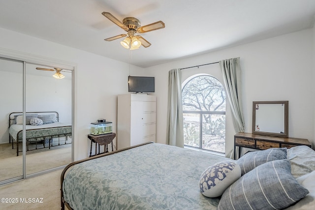 bedroom with a ceiling fan, a closet, and light colored carpet