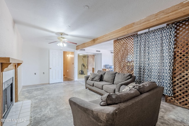 living room with beamed ceiling, ceiling fan, visible vents, a tile fireplace, and light carpet