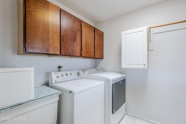 laundry area with cabinet space, independent washer and dryer, and baseboards