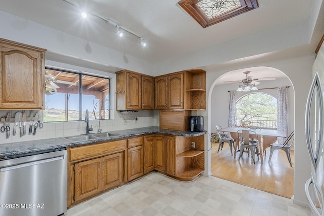 kitchen with brown cabinetry, stainless steel appliances, open shelves, and a sink