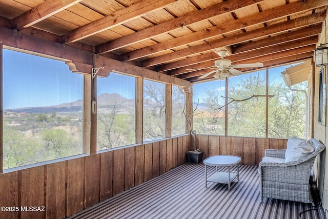 sunroom with beamed ceiling, ceiling fan, and a mountain view