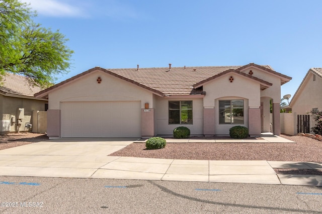 view of front of house with stucco siding, a garage, concrete driveway, and a tile roof