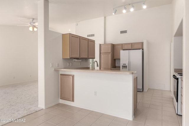 kitchen featuring black range with electric stovetop, visible vents, ceiling fan, and white refrigerator with ice dispenser