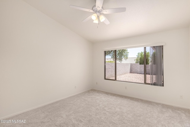 empty room with baseboards, ceiling fan, lofted ceiling, and carpet