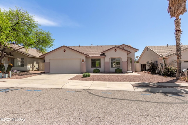 mediterranean / spanish-style home with concrete driveway, a garage, stucco siding, and a tiled roof