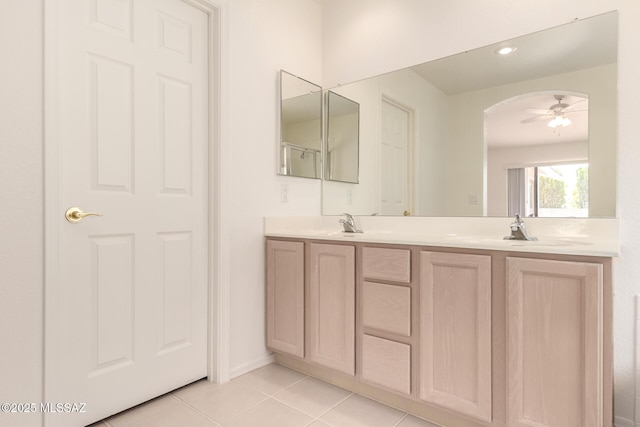 bathroom with a sink, tile patterned floors, a ceiling fan, double vanity, and baseboards