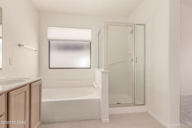 full bath featuring vanity, tile patterned floors, a stall shower, baseboards, and a garden tub