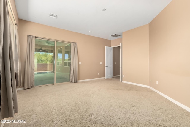empty room with baseboards, visible vents, and carpet