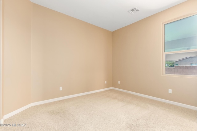 carpeted spare room with visible vents and baseboards