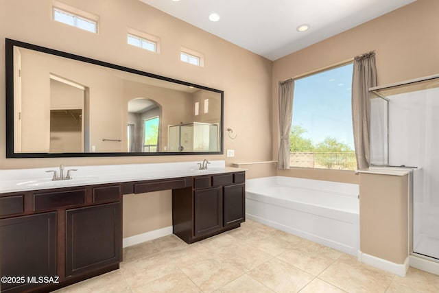 full bathroom featuring double vanity, a sink, a bath, and a stall shower