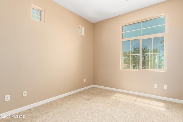spare room with baseboards and carpet