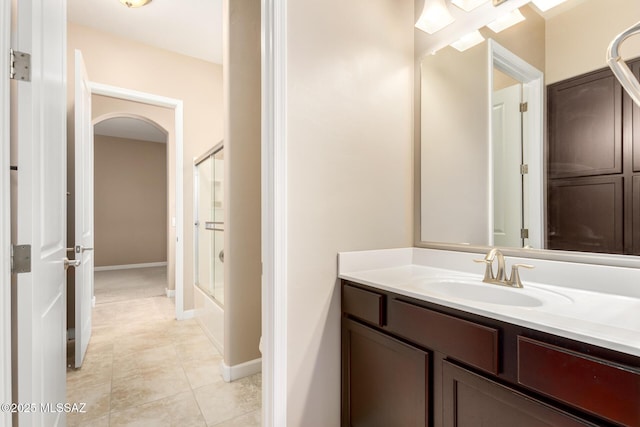 bathroom with vanity, baseboards, bath / shower combo with glass door, and tile patterned floors