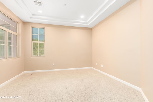 carpeted empty room with baseboards, a tray ceiling, recessed lighting, and visible vents