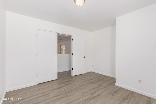 spare room featuring wood finished floors and baseboards
