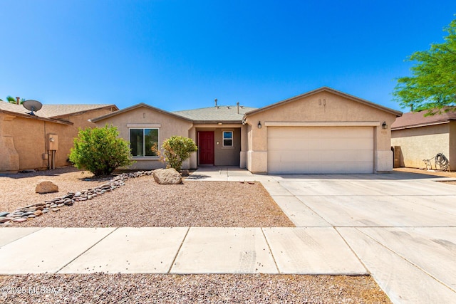single story home with driveway, an attached garage, and stucco siding