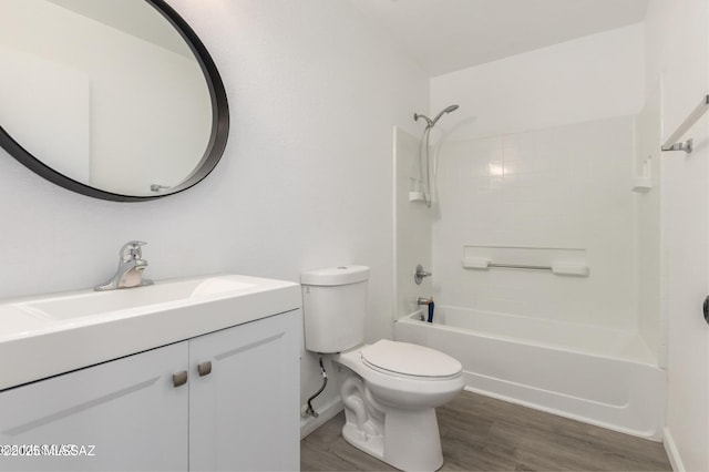 bathroom with baseboards, toilet, wood finished floors, vanity, and bathtub / shower combination