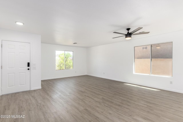 unfurnished living room with recessed lighting, a ceiling fan, visible vents, baseboards, and wood finished floors