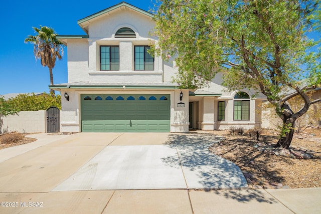 view of front of house with fence, an attached garage, stucco siding, a gate, and driveway