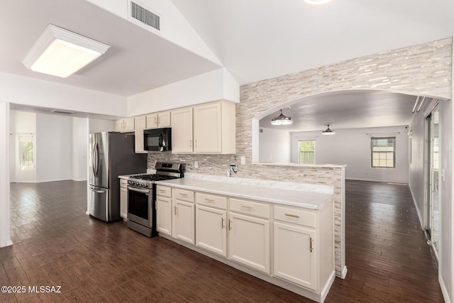 kitchen featuring light countertops, stainless steel appliances, open floor plan, decorative backsplash, and visible vents