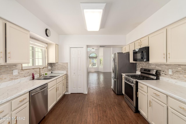 kitchen with a sink, appliances with stainless steel finishes, backsplash, and a healthy amount of sunlight