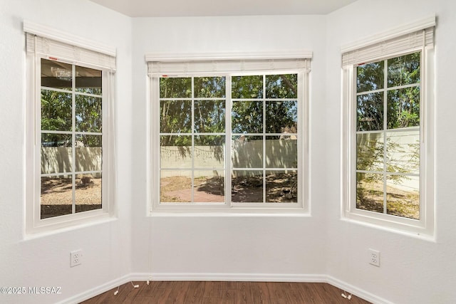 interior space featuring baseboards and dark wood-style floors