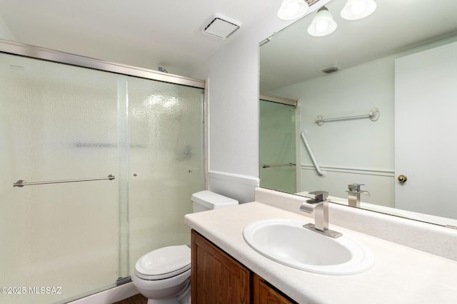 bathroom featuring visible vents, vanity, toilet, and a shower stall