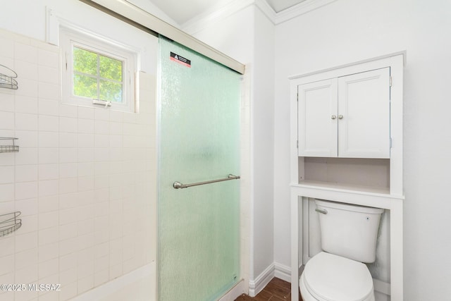 full bathroom with a stall shower, toilet, and wood finished floors