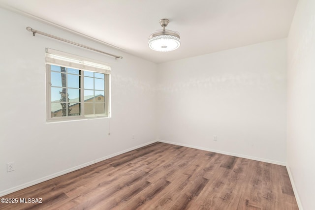 empty room with baseboards and wood finished floors
