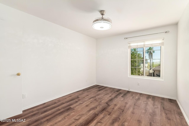 empty room featuring baseboards and wood finished floors