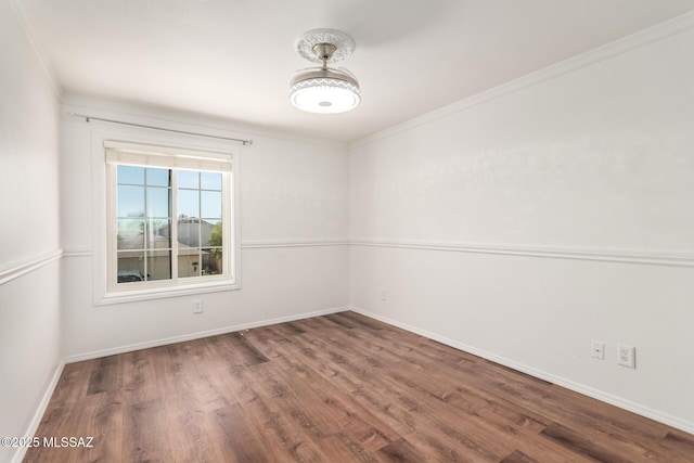 unfurnished room featuring crown molding, baseboards, and wood finished floors