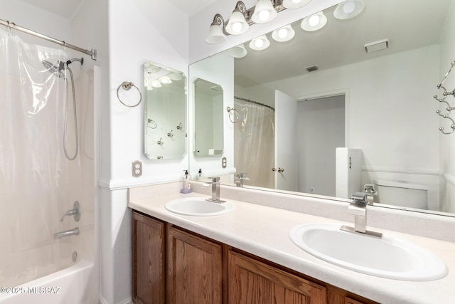 full bathroom featuring double vanity, shower / bath combo with shower curtain, visible vents, and a sink