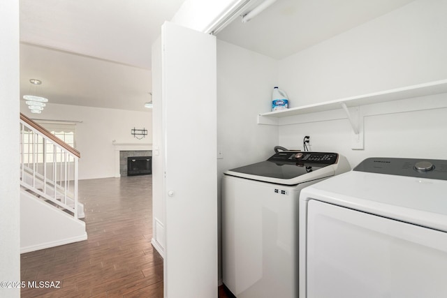 washroom featuring laundry area, a tile fireplace, independent washer and dryer, and wood finished floors
