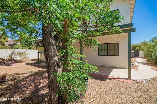 exterior space with a patio, fence, a fire pit, and stucco siding