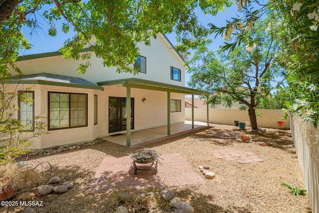 back of house featuring a patio area, stucco siding, a fire pit, and fence
