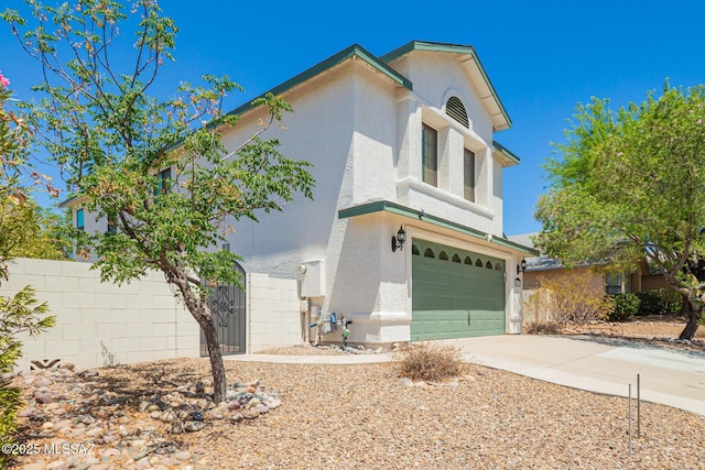view of front facade featuring a garage, fence, stucco siding, and concrete driveway