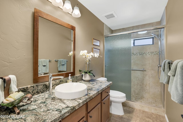 bathroom with vanity, visible vents, a shower stall, and toilet