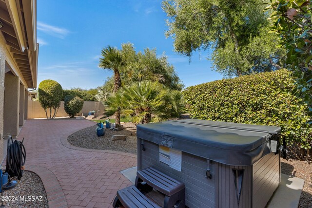 view of patio with a fenced backyard and a hot tub